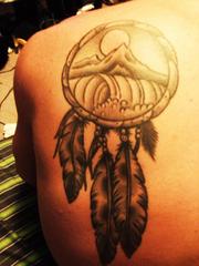 tatouage sur l'épaule d'un attrape rêve avec montagne